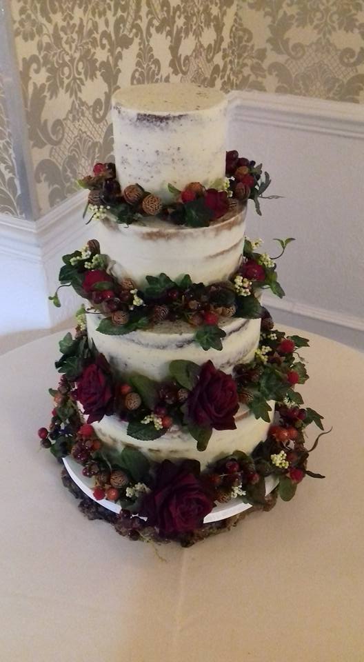 Semi-naked wedding cake with autumn flowers, nuts and leaves